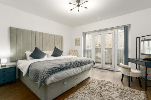 a bedroom with a bed and a desk and a window at Nottage House Premier Apartments in Cardiff