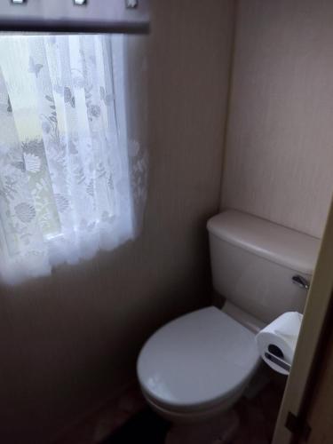 a bathroom with a white toilet and a window at Ingoldmells Skegness holiday break at coral beach by Hannah in Lincolnshire