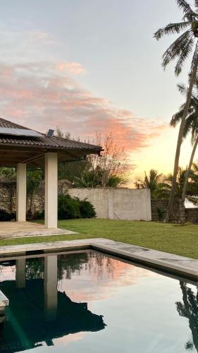 a swimming pool in front of a house at Manna Villa - Sovereign Palms CI in Arorangi
