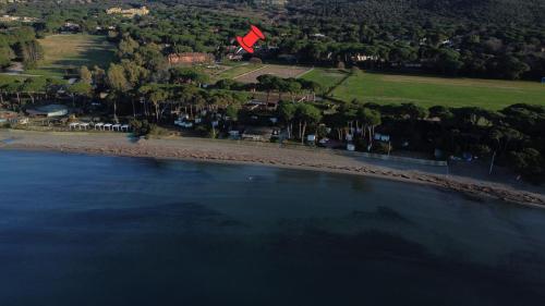 an aerial view of a beach with a red kite at La Casina Punta Ala in Punta Ala