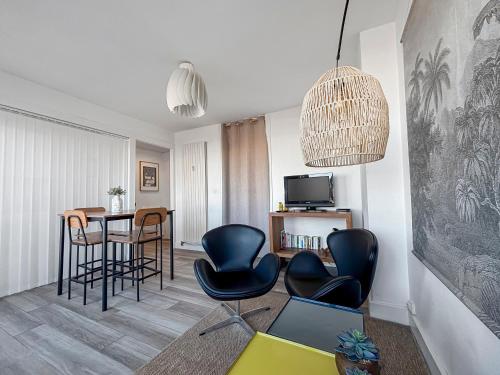 a living room with black chairs and a table at Chic & lumineux avec balcon in Calais