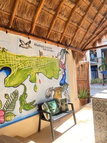a bench in front of a wall with a mural at Hotel Pelecanus Suites Holbox in Holbox Island