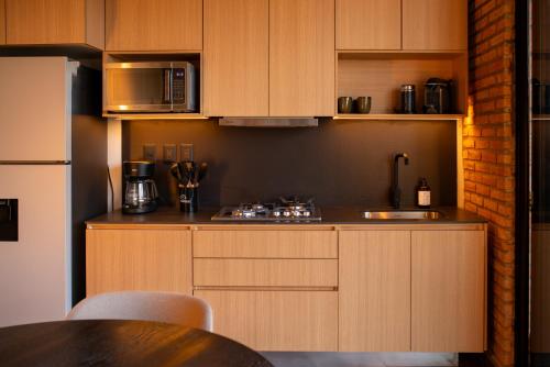 a kitchen with wooden cabinets and a counter top at Mana by Pardela in Guadalajara