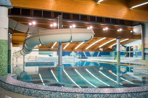 a swimming pool with a water slide in a building at Wellness apartmán Frymburk D403 Čtvrté patro in Frymburk