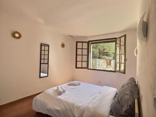 une chambre avec un lit blanc et une fenêtre dans l'établissement Villa au cœur de la Provence, à Lorgues