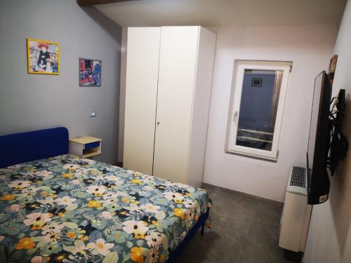 a bedroom with a bed and a cabinet and a window at Casa LaSer in Cotignola