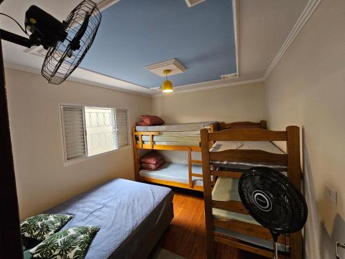 a bedroom with two bunk beds and a fan at Recanto Margarida in Socorro