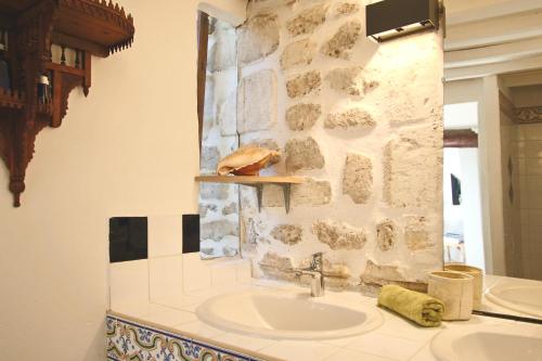 a bathroom with a sink and a stone wall at Studio St Rémy Historic Center/Air-com in Saint-Rémy-de-Provence