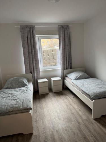 a bedroom with two beds and a window at Neu und Günstig! Hochwertige Ferien- und Monteurswohnung bei Leipzig Nähe A14 in Taucha