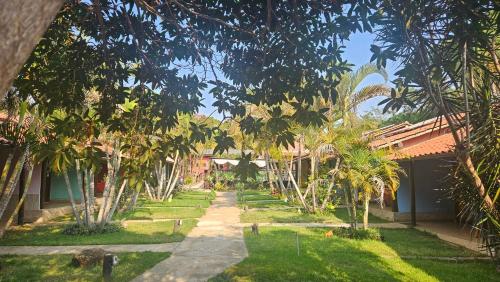 a pathway lined with palm trees next to a house at Pousada Cipó Prata in Serra do Cipo
