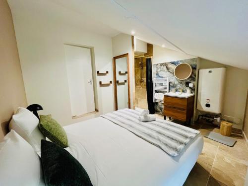 - une chambre avec un grand lit blanc et un lavabo dans l'établissement Repos Cosy à Bourgoin avec Parking privatif, à Bourgoin-Jallieu