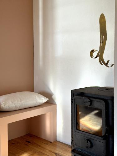 a living room with a stove and a bed at Atelier Blå houses in Rösselvik