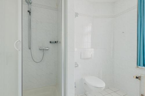 a white bathroom with a shower and a toilet at Pension für Monteure in Dresden, Zimmer mit eigenem Bad und großer Gemeinschaftsküche in Dresden