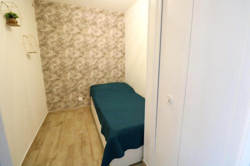 Cette petite chambre d'angle comprend un lit vert. dans l'établissement Appartement PORT SAINT CYPRIEN, à Saint Cyprien Plage