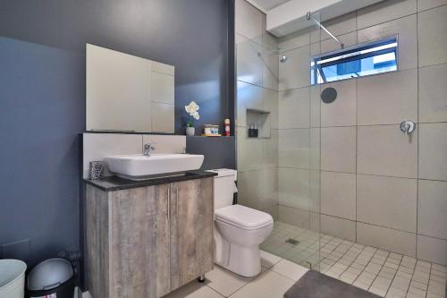 une salle de bains avec lavabo, toilettes et douche dans l'établissement Luxury Lowveld Apartment, à Nelspruit