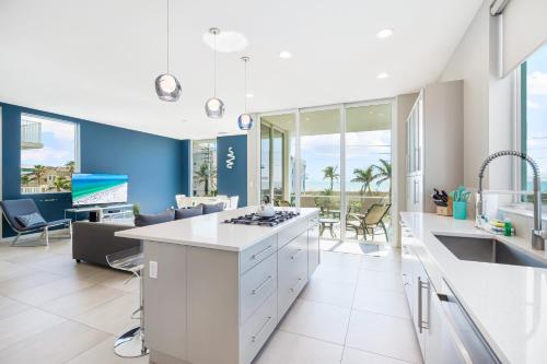a kitchen with white cabinets and a living room at Lookout in Siesta Key
