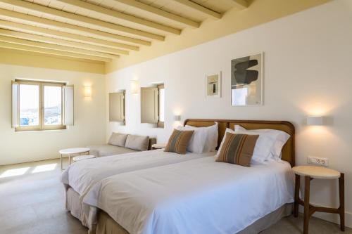 a bedroom with two beds and two windows at Camarades Mykonos in Ano Mera