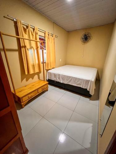 a small room with a bed and a window at kasada Nanda in Pirenópolis