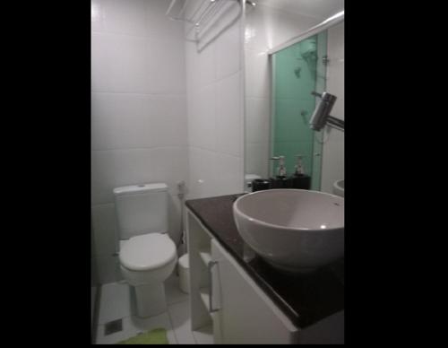 a bathroom with a white toilet and a sink at Ajuricaba Suites 1 in Manaus