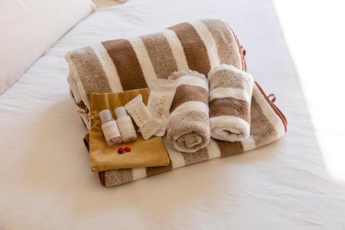 a basket with towels and other items on a bed at Roots of Rome Apartment in Rome