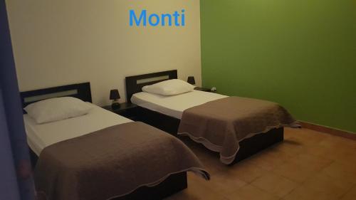 - 2 lits dans une chambre avec un panneau mural dans l'établissement Gite de 90m2 proche de la mer avec grande piscine MONTI, à Canale-di-Verde