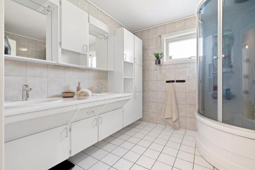 トロンハイムにあるWorld Cup Trondheim 2025の洗面台とシャワー付きの白いバスルーム