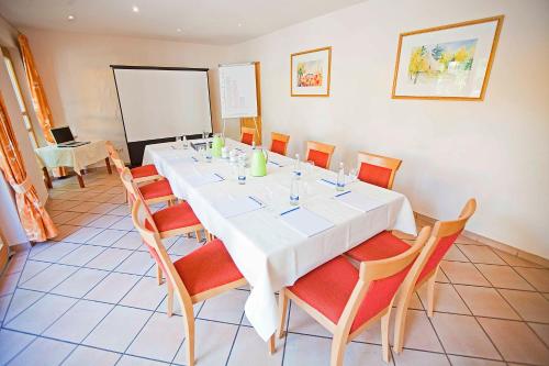 a dining room with a white table and chairs at Hotel Gasthof Engel in Appenweier