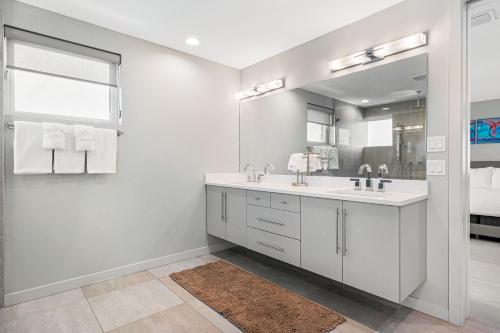 a white bathroom with two sinks and a mirror at Lookout in Siesta Key