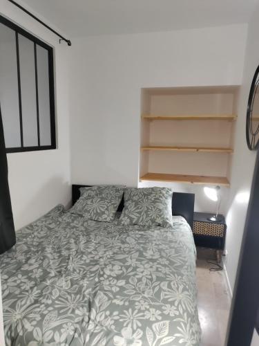 - une chambre avec un lit et une couette grise et blanche dans l'établissement Studio du BoisDHyver, à Fontainebleau