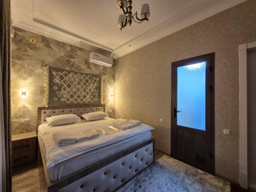 a bedroom with a bed and a window and a door at YASMIN in Samarkand