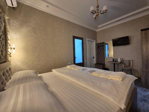 a bedroom with two beds and a window at YASMIN in Samarkand