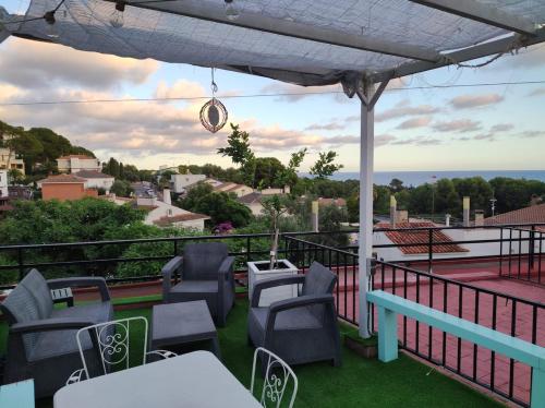 a patio with chairs and tables on a balcony at Estudio en la playa in Molnás