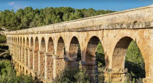an old stone bridge with arches on top of it at Estudio en la playa in Molnás