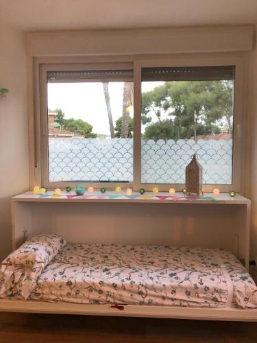 a bed in front of a window with a window sill at Estudio en la playa in Molnás