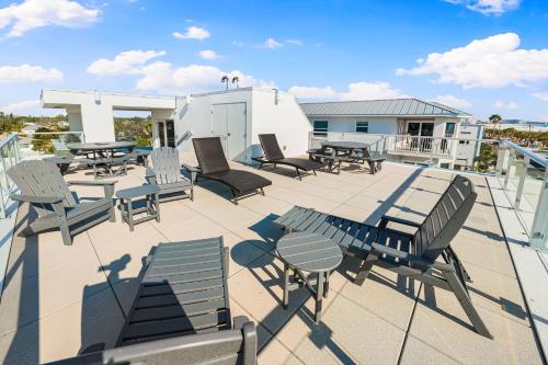 a patio with tables and chairs on a roof at Lookout in Siesta Key