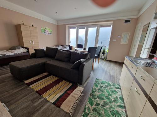 a living room with a couch and a bed at Két Sirály Apartman in Siklós