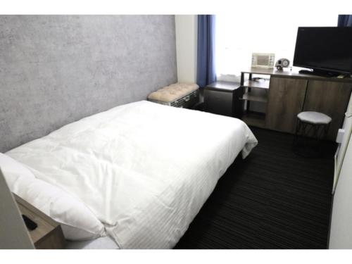 a bedroom with a white bed and a television at Business Hotel B,loom - Vacation STAY 38190v in Tanabe