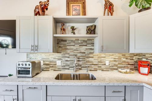 a kitchen with white cabinets and a sink at Cozy Couples Retreat with Views in Apache Junction in Apache Junction