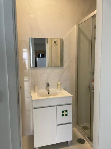 a bathroom with a white sink and a shower at Albina's Guest House - Private Patio and Garden - 5 min Walk to Beach! in Leça da Palmeira