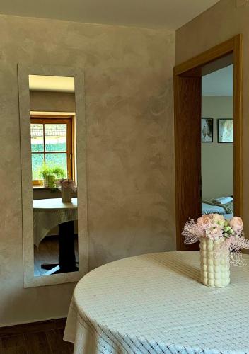 a room with a table with a vase of flowers at Kuća za odmor u prirodi Ivana in Ilok