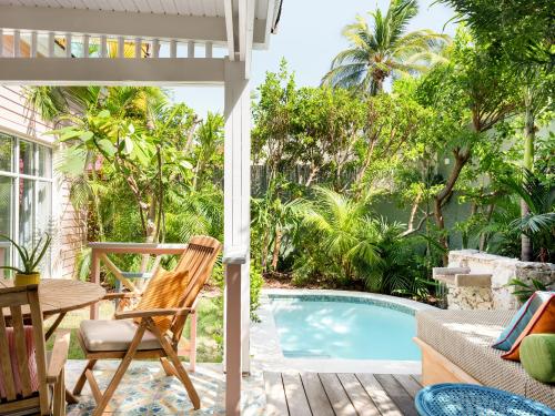 a patio with a table and chairs and a swimming pool at Boardwalk Boutique Hotel Aruba - Adults Only in Palm-Eagle Beach