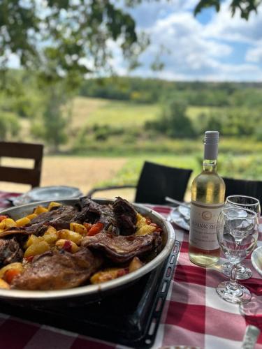 a plate of food on a table with a bottle of wine at Kuća za odmor u prirodi Ivana in Ilok