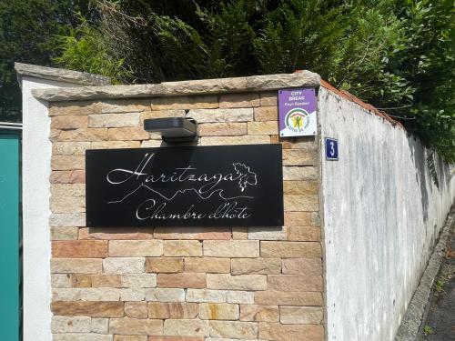 a brick wall with a sign on it at HARITZAGA chambre d'hôte terrasse & jardin privé in Biarritz