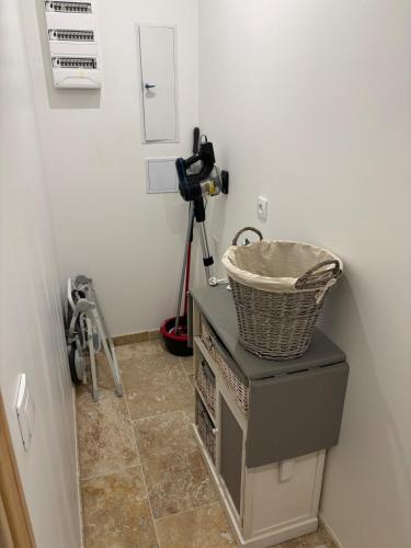 une chambre avec un panier au-dessus d'une machine dans l'établissement Maison au calme à Pessac Sur Dordogne, à Pessac-sur-Dordogne