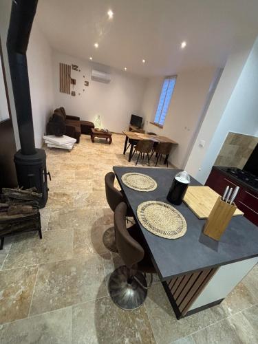 un salon avec une table et une cheminée dans l'établissement Maison au calme à Pessac Sur Dordogne, à Pessac-sur-Dordogne