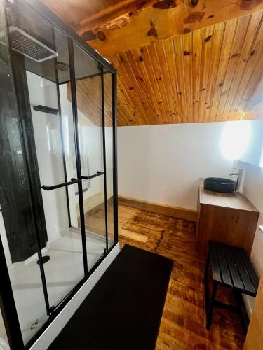 une chambre avec un banc et une paroi en verre dans l'établissement Maison de Margaux - Montagne, à Puyvalador