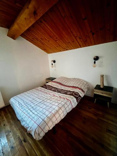 un lit dans une chambre avec un plafond en bois dans l'établissement Maison de Margaux - Montagne, à Puyvalador