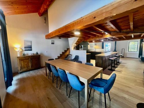 une salle à manger avec une table en bois et des chaises bleues dans l'établissement Maison de Margaux - Montagne, à Puyvalador