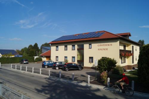a man riding a bike in front of a building at Gästehaus Wagner in Egglfing
