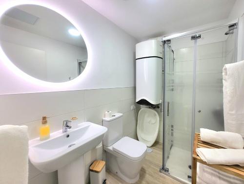 a bathroom with a sink and a toilet and a mirror at Arguineguin Sun Beach in Arguineguín